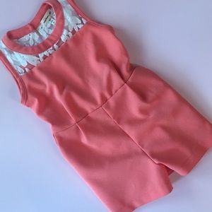 Peachy orange romper with lace detailing.